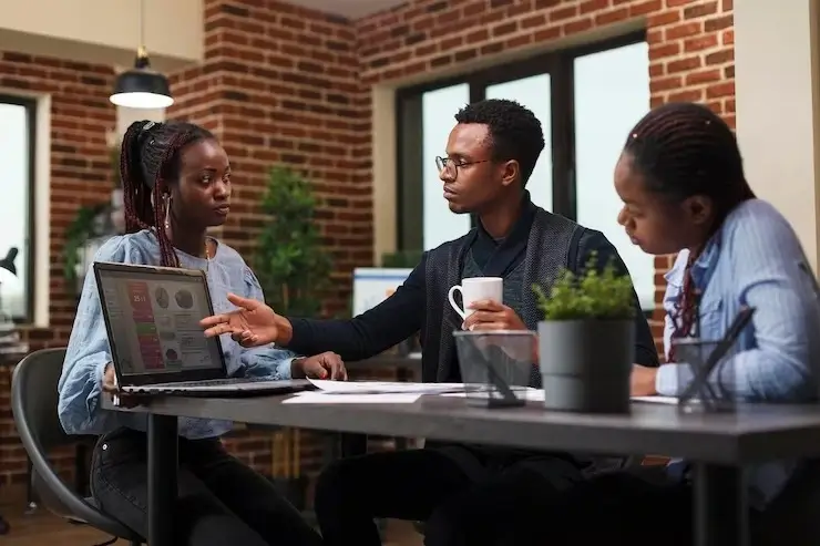 Three colleagues at work discussing a project