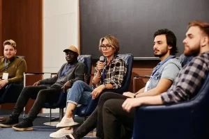 Woman speaking to a group of people using a microphone.