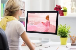 Woman working at her desk creating a website on her computer