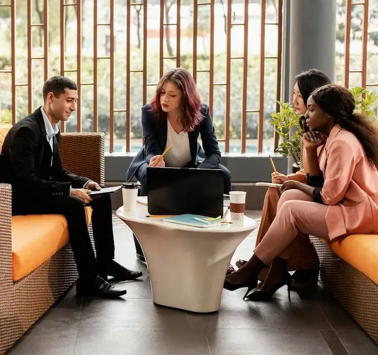 A female professional leading a discussion with her colleagues.