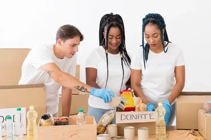 Three dedicated volunteers coordinating items for donation.